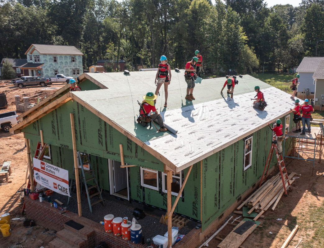 A team of house crew leaders on the roof of a house under construction learning how to install a GAF roofing system.